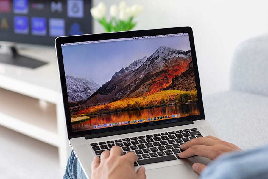 Customer checking MacBook Pro condition before purchase at PayMore Wake Forest